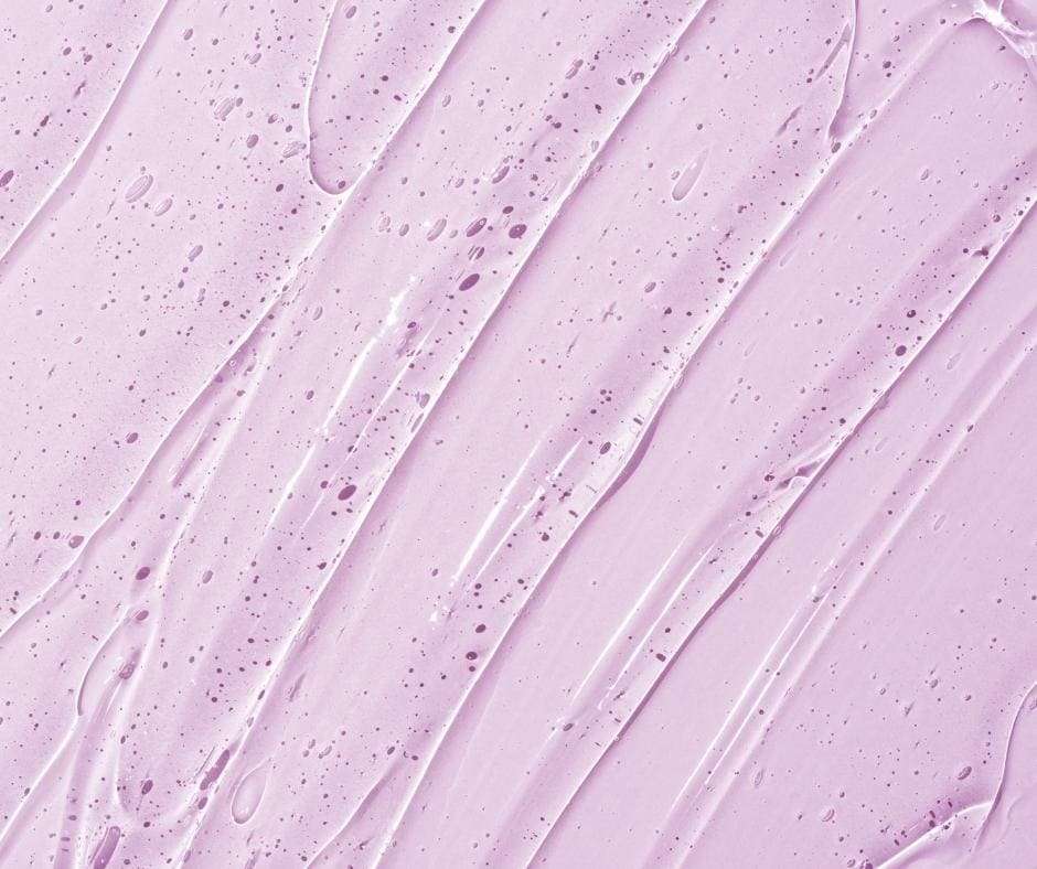 Nahaufnahme einer kosmetischen Flüssigkeit auf hellviolettfarbenem Hintergrund